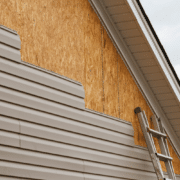 Illustration of professional roofers installing new siding on a house