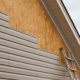 Illustration of professional roofers installing new siding on a house