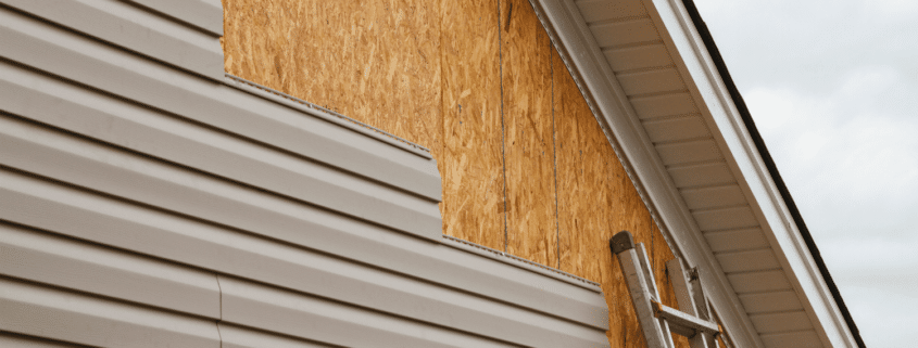 Illustration of professional roofers installing new siding on a house