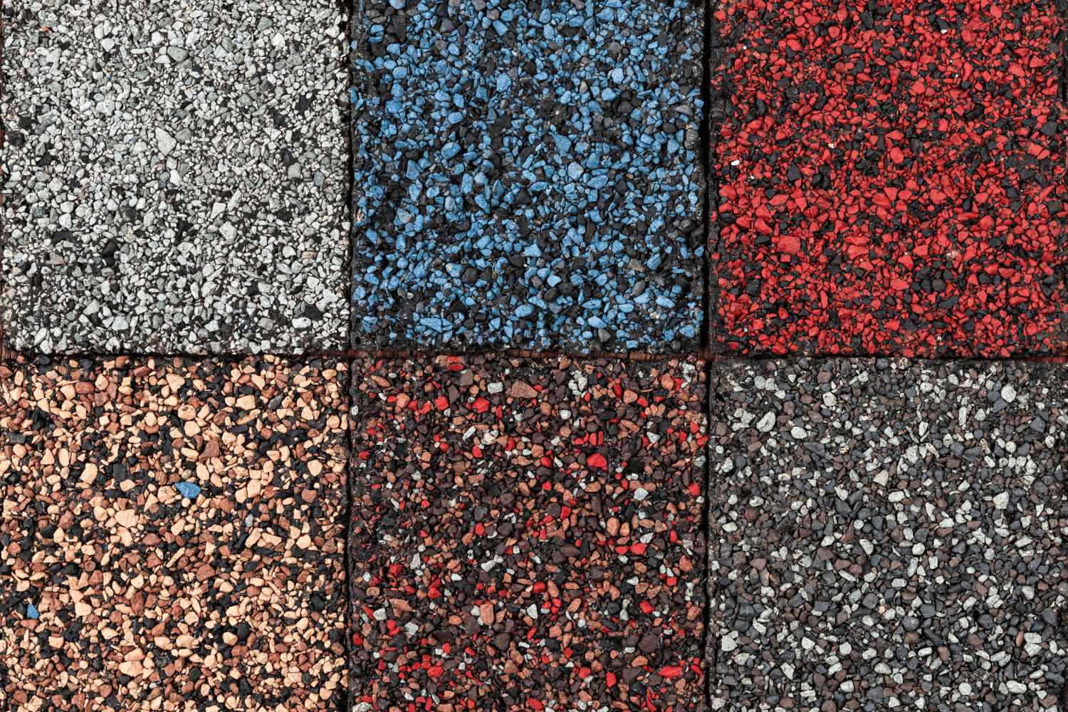 The image displays various colors of asphalt shingles, a common roofing material. 