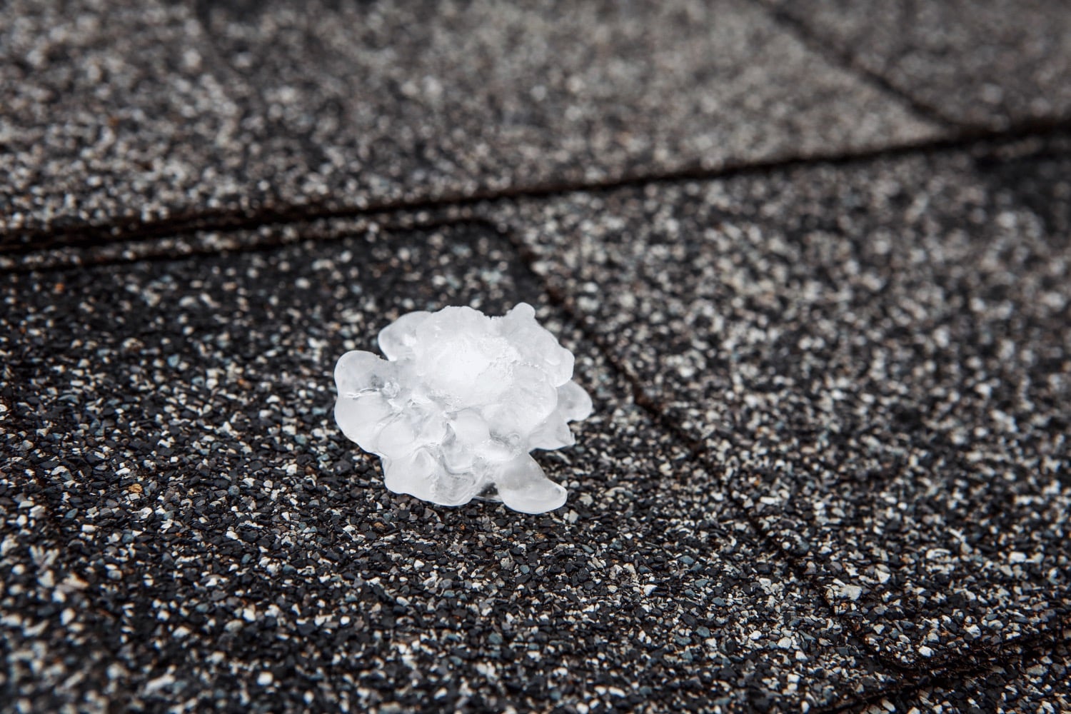 An illustration depicting the assessment of hail damage on a roof, highlighting damaged areas and tools used.