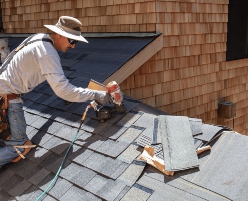 An illustration of a roofing contractor assessing a damaged roof for emergency repairs.