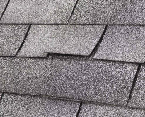 The image displays asphalt shingles, a common roofing material.