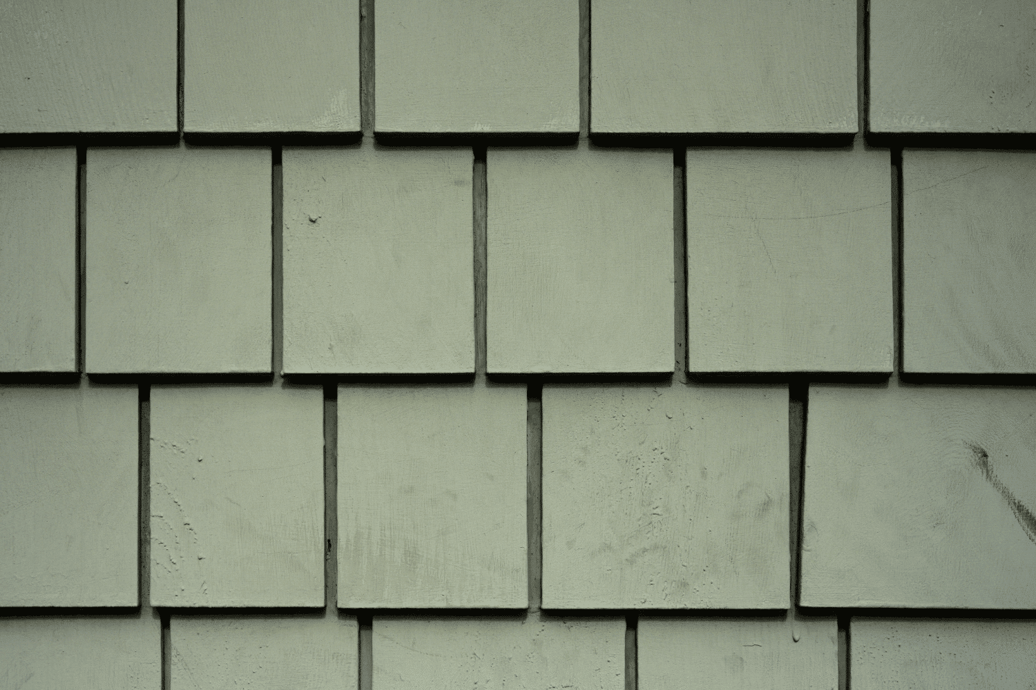 Installing James Hardie shingle siding on a house.